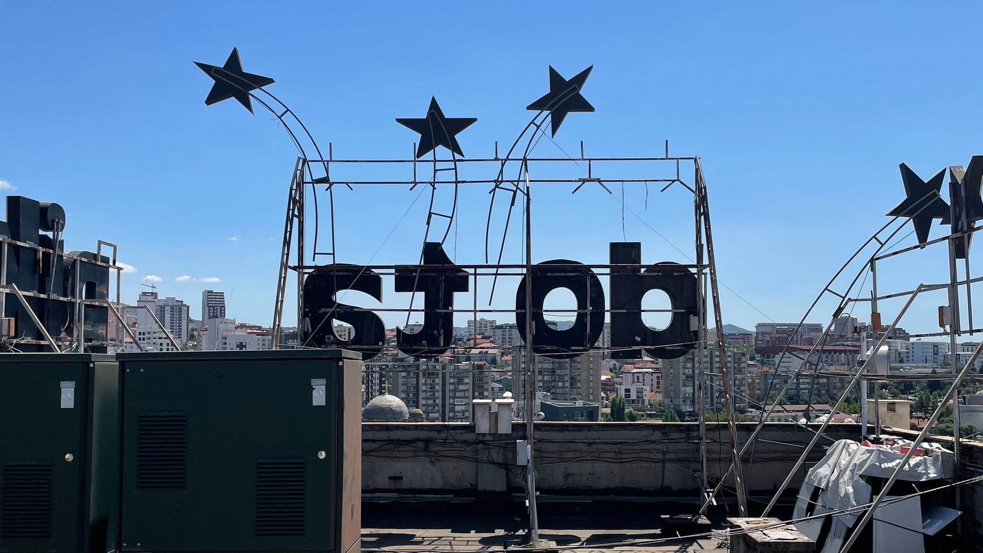 Blick vom Dach des Grand Hotels Pristina, Hauptspielort der Manifesta, ein Schriftzug und viele Sterne sind auf dem Dach angebracht. Blick vom Dach des Grand Hotels Pristina, Hauptspielort der Manifesta, ein Schriftzug und viele Sterne sind auf dem Dach angebracht.
