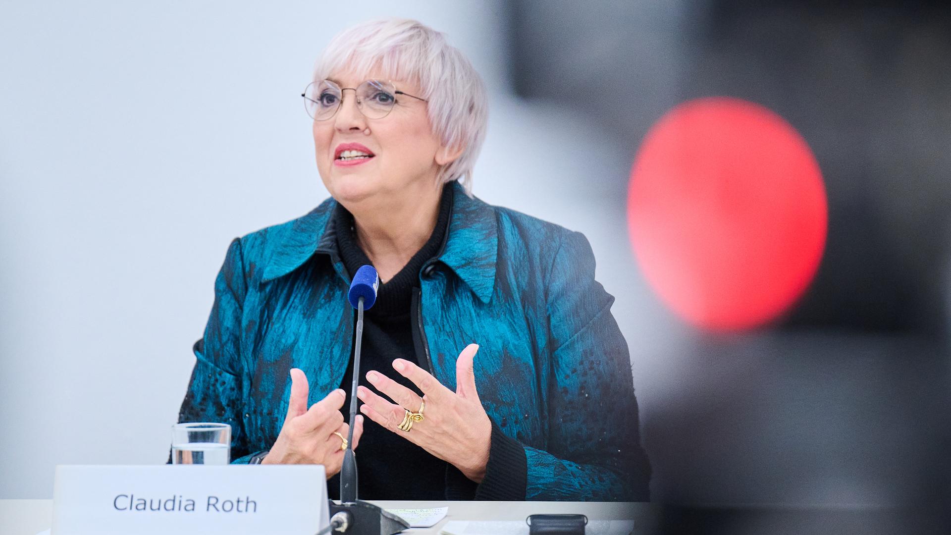 Claudia Roth. Eine ältere Frau mit kurzen hellen Haaren und Brille steht an einem Pult und hält eine Rede. Claudia Roth. Eine ältere Frau mit kurzen hellen Haaren und Brille steht an einem Pult und hält eine Rede.