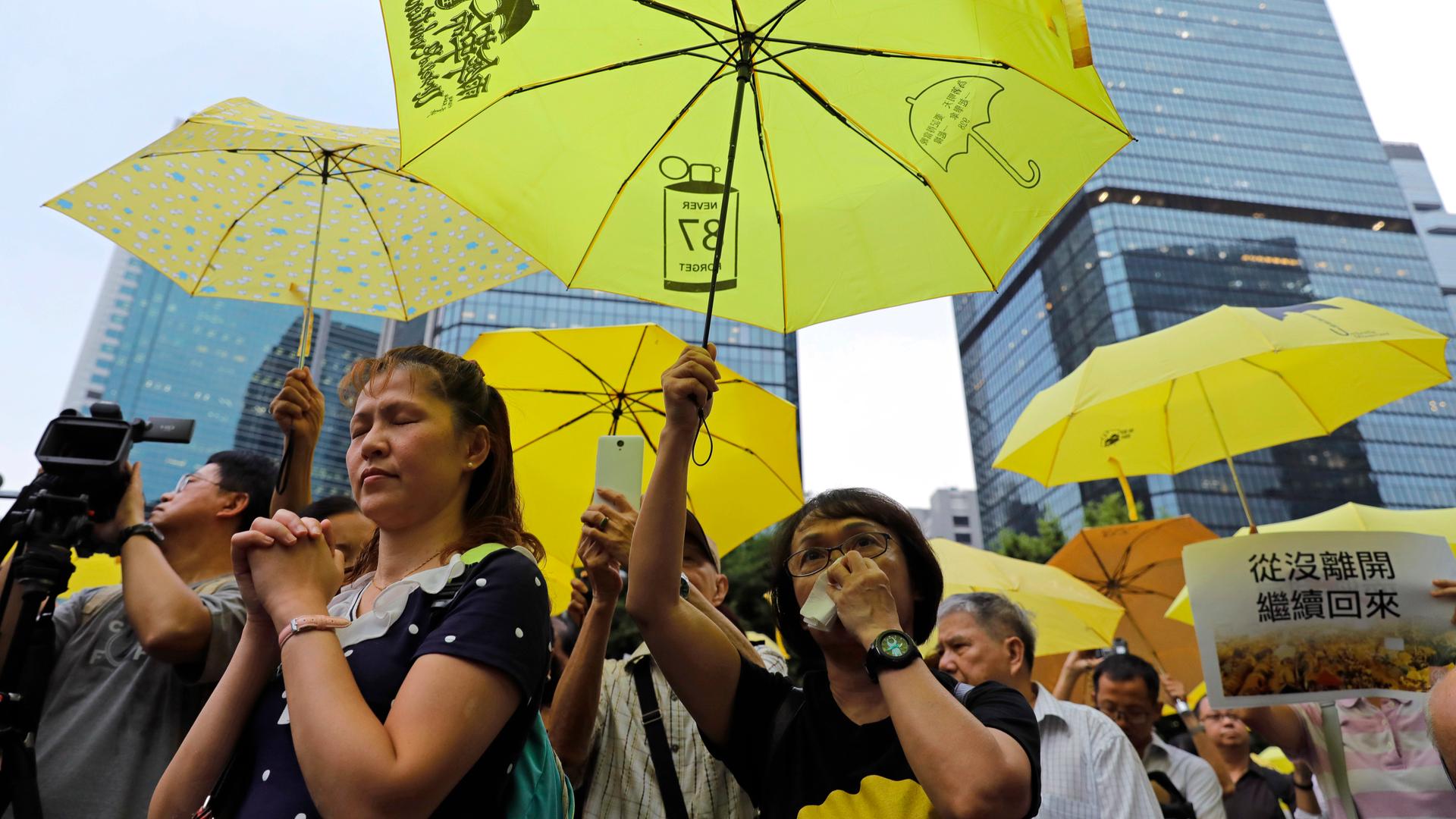 Demonstrierende in Hongkong. Sie tragen  gelbe Schirme.