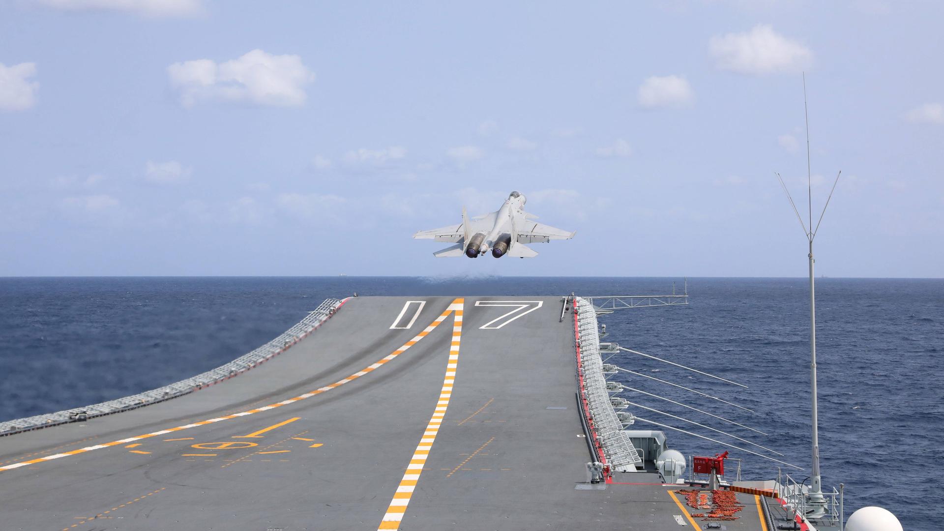 Ein chinesischer Kampfjet steigt von einem Flugzeugträger auf. Ein chinesischer Kampfjet steigt von einem Flugzeugträger auf.