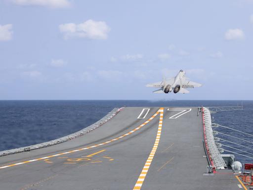 Ein chinesischer Kampfjet steigt von einem Flugzeugträger auf. 