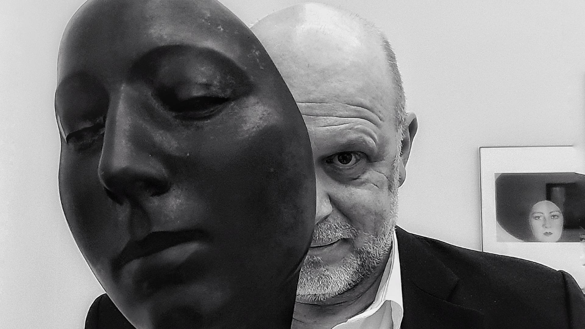 Der Fotokünstler Gregor Wildförster schaut hinter der Skulptur eines Gesichtes hervor. Sein Gesicht ist auf der Schwarz-Weiß-Fotografie dabei nur zur Hälfte zu sehen. Der Fotokünstler Gregor Wildförster schaut hinter der Skulptur eines Gesichtes hervor. Sein Gesicht ist auf der Schwarz-Weiß-Fotografie dabei nur zur Hälfte zu sehen.