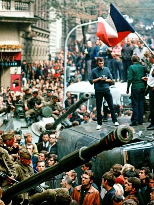 August 1968, Tschechoslowakei, Prag: Protestierer umringen in der Innenstadt sowjetische Panzer und stehen mit einer Fahne der Tschechoslowakei auf einem umgekippten Militärfahrzeug.