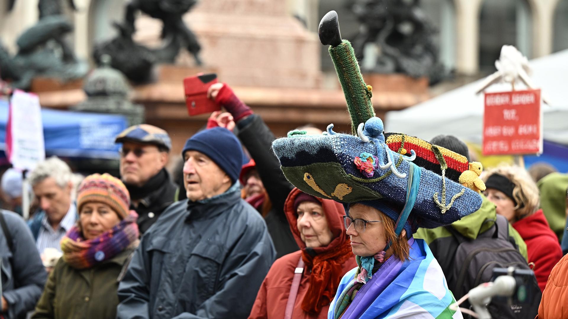 Eine Teilnehmerin am Ostermarsch trägt einen Strickhut, der einen Panzer darstellt.
