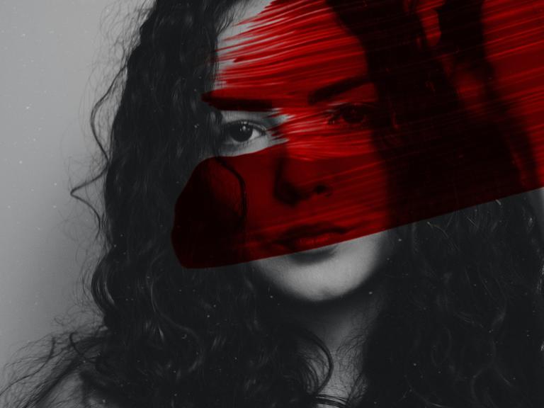 Eine Frau mit dunklen Locken. Quer über das Bild geht ein roter Streifen Farbe.