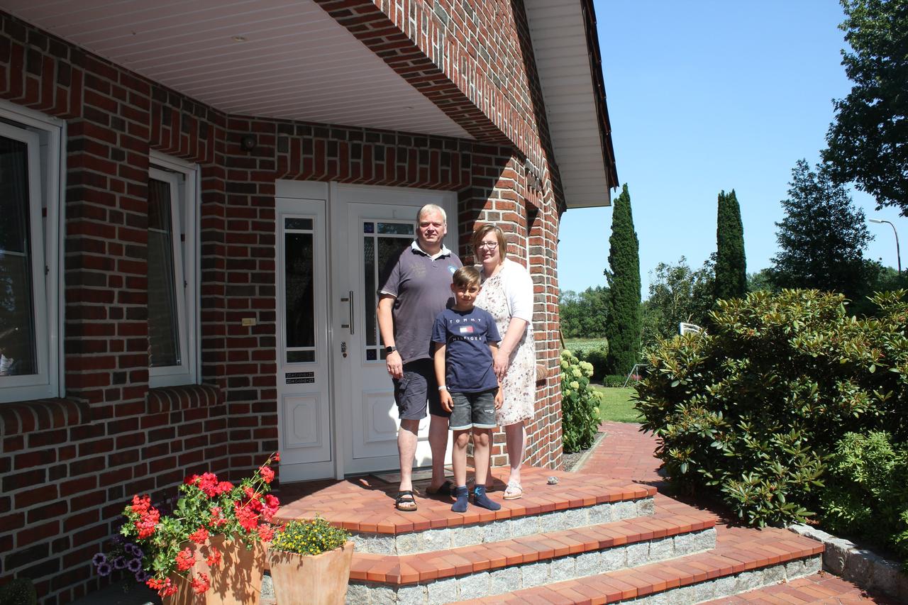 Familie Möllerhaus vor ihrem Heim stehend bei strahlendem Sonnenschein. Familie Möllerhaus vor ihrem Heim stehend bei strahlendem Sonnenschein.