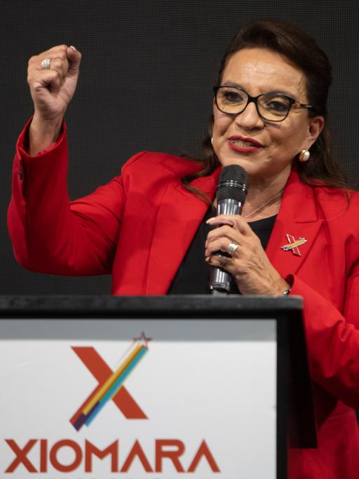 Xiomara Castro steht mit geballter Faust auf einem Podium