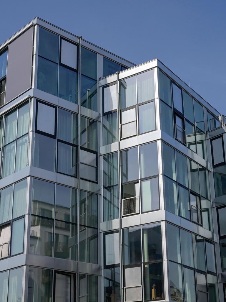 Blick auf eine von viel Glas- und Fensterflächen dominierte Fassade eine Neubaus als Wohnhaus in Berlin Schöneberg.