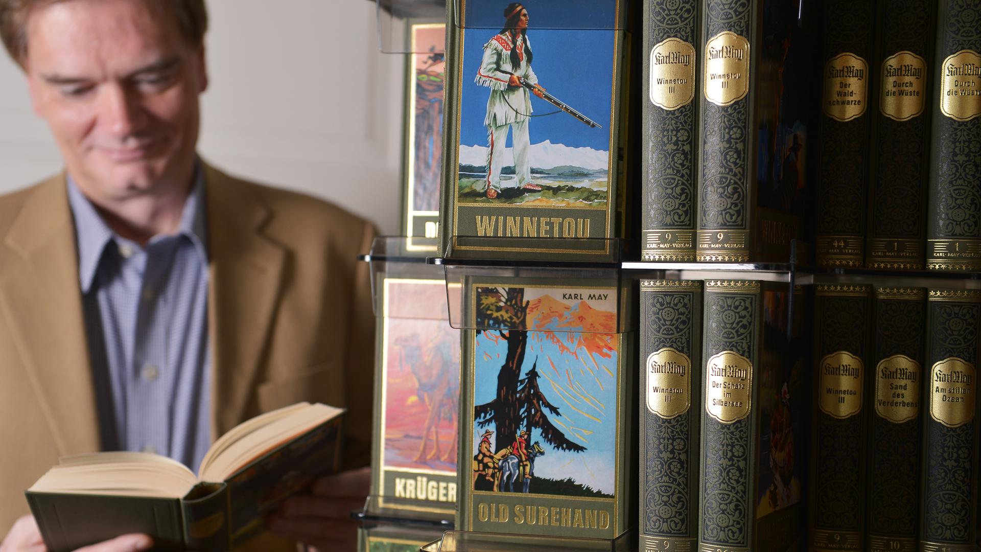Bernhard Schmid, Chef des Bamberger Karl-May-Verlags, blättert am 25.06.2013 in seinem Büro in Bamberg (Bayern) in einem Winnetou-Buch. Der Verlag wurde vor 100 Jahren am 1. Juli 1913 gegründet und konzentriert sich bis heute allein auf Karl May (1842-1912). Foto: David Ebener/dpa (zu dpa-lby "Karl-May-Verlag Bamberg feiert Jubiläum" vom 28.06.2013) ++