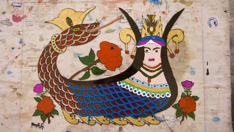Eine Zeichnung auf Glass der mesopotamischen Schlangengöttin Sahmeran. Ihr Oberkörper ist der einer Frau, der Unterkörper ist der einer Schlange, mit einem Schlangenkopf am anderen Ende.