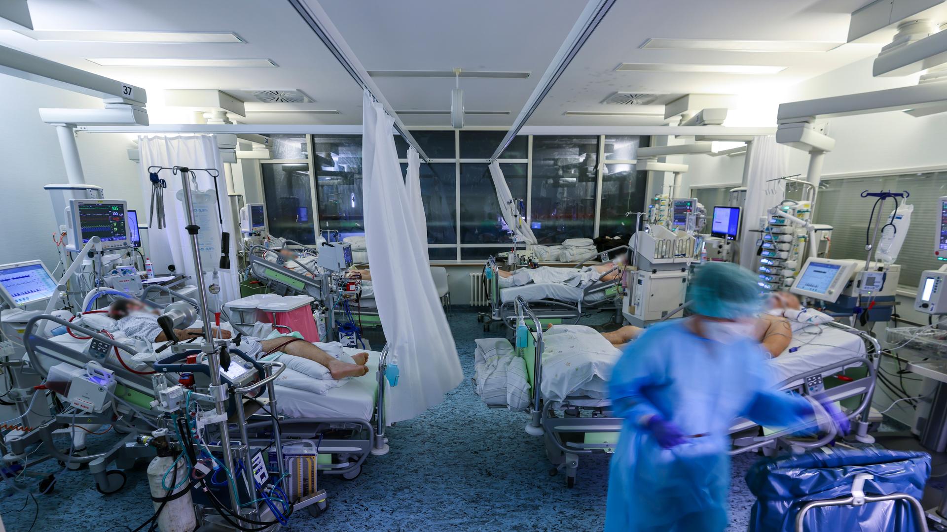 Eine Intensivpflegerin versorgt einen Covid-19-Patienten auf der Intensivstation der Leipziger Uniklinik in einem Zimmer, in dem noch drei weitere Corona-Patienten liegen. Eine Intensivpflegerin versorgt einen Covid-19-Patienten auf der Intensivstation der Leipziger Uniklinik in einem Zimmer, in dem noch drei weitere Corona-Patienten liegen.