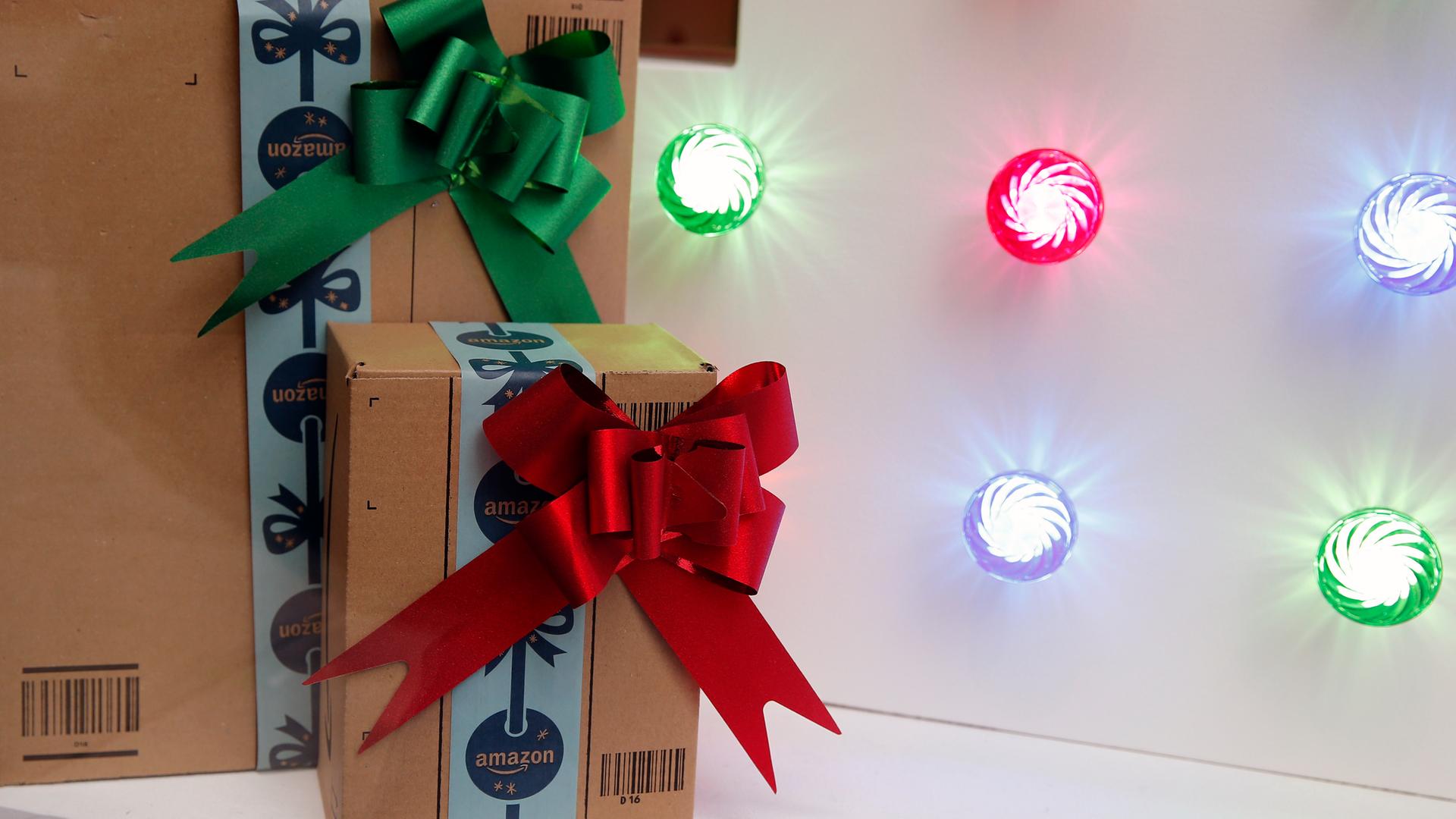 Zwei weihnachtlich verpackte Geschenkboxen des Versandhändlers Amazon. 