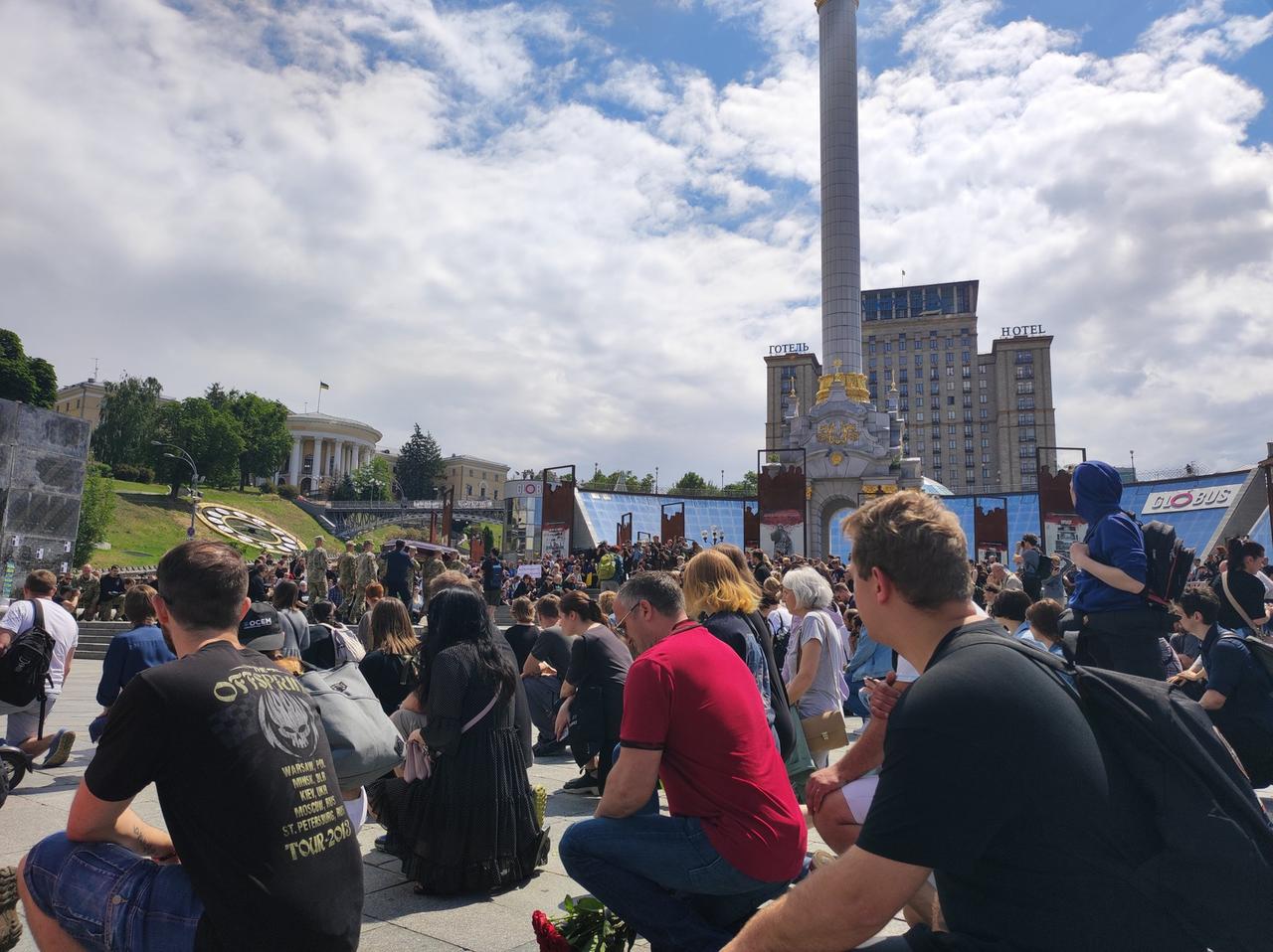 Menschen sitzen im Juni in Kiew auf einem Platz und trauern. 