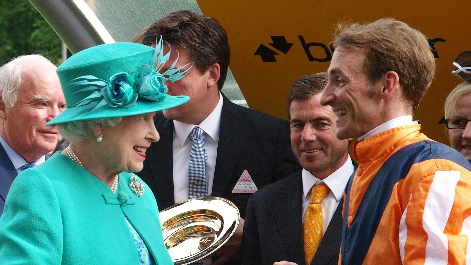 Queen Elizabeth II unterhält sich bei der Siegerehrung mit dem Deutschen Jockey Andrasch Starke beim Pferderennen in Ascot 2012. Queen Elizabeth II unterhält sich bei der Siegerehrung mit dem Deutschen Jockey Andrasch Starke beim Pferderennen in Ascot 2012.