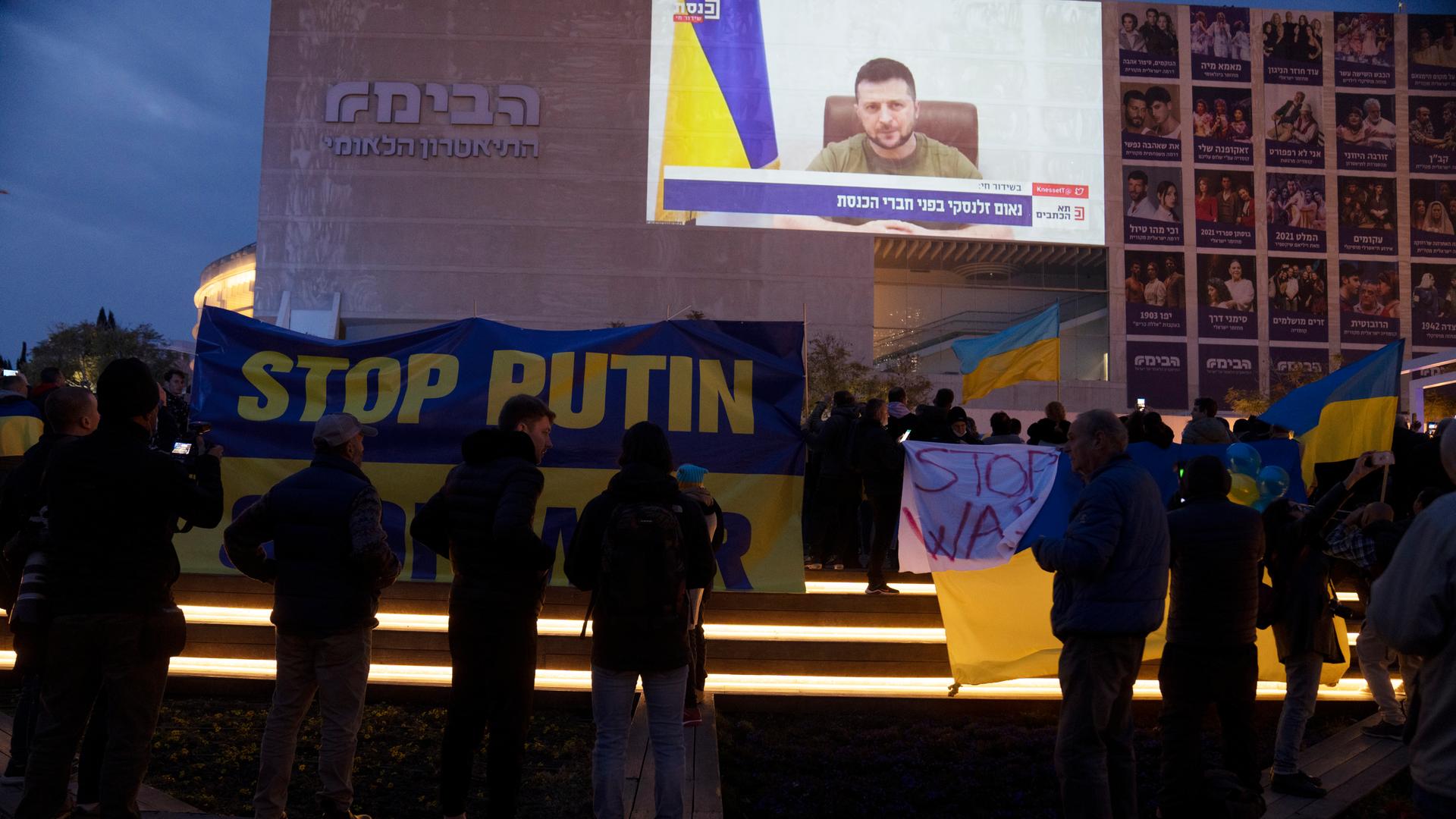 Menschen versammeln sich auf dem Habima Square in Tel Aviv, Israel, um die Video-Ansprache des ukrainischen Präsidenten vor der Knesset anzuschauen Menschen versammeln sich auf dem Habima Square in Tel Aviv, Israel, um die Video-Ansprache des ukrainischen Präsidenten vor der Knesset anzuschauen