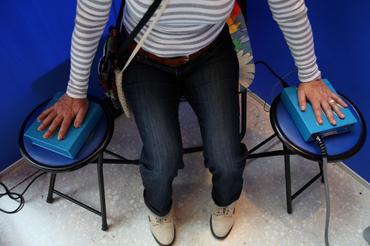 Eine Frau hält auf der Esoterikmesse in Köln ihre Hände für eine Aura-Foto auf Sensoren. Eine Frau hält auf der Esoterikmesse in Köln ihre Hände für eine Aura-Foto auf Sensoren.