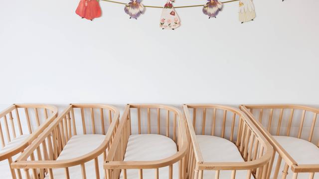 Leere Kinderbetten aus Holz stehen dicht nebeneinander. Leere Kinderbetten aus Holz stehen dicht nebeneinander.