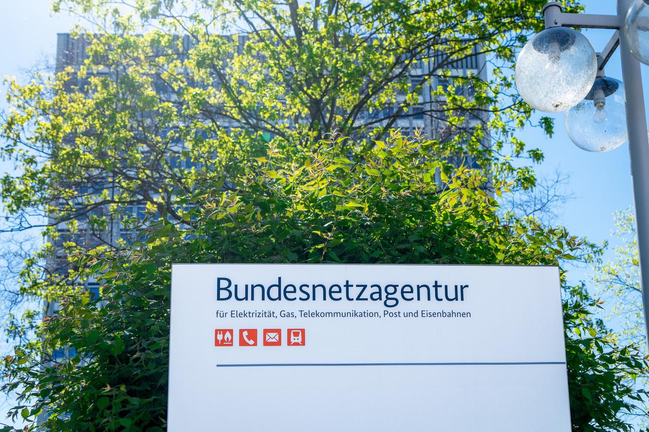 Schild mit der Aufschrift "Bundesnetzagentur", dahinter ein durch einen Baum weitgehend verdecktes Hochhaus. Schild mit der Aufschrift "Bundesnetzagentur", dahinter ein durch einen Baum weitgehend verdecktes Hochhaus.