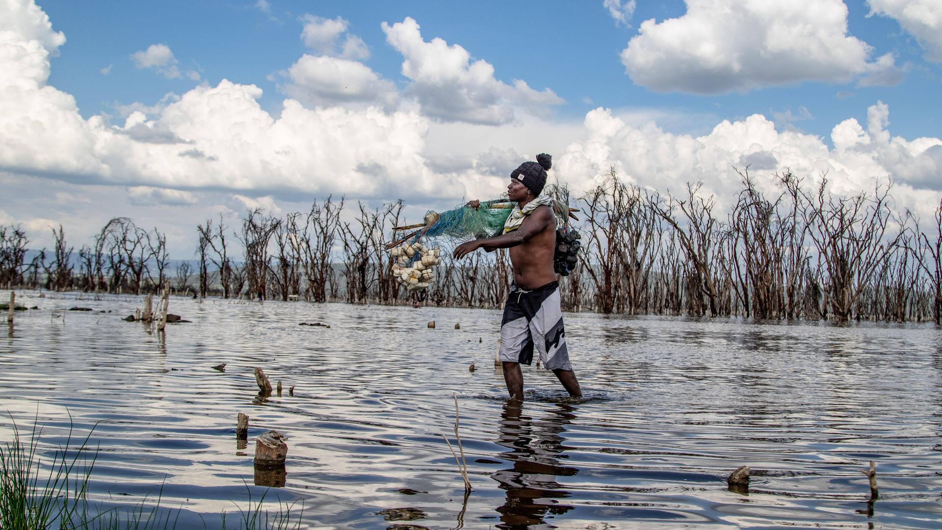 Ein Fischer am Nakurusee in Kenia: Durch den Klimawandel läuft der See quasi über, breitet sich immer weiter aus. Viele Menschen haben dadurch Häuser und Arbeit verloren. Ein Fischer am Nakurusee in Kenia: Durch den Klimawandel läuft der See quasi über, breitet sich immer weiter aus. Viele Menschen haben dadurch Häuser und Arbeit verloren.