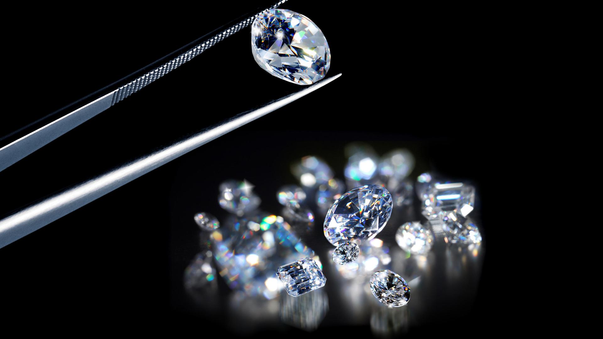 Eine Pinzette, die einen Diamanten hält. Im Hintergrund weitere wertvolle Steine Eine Pinzette, die einen Diamanten hält. Im Hintergrund weitere wertvolle Steine