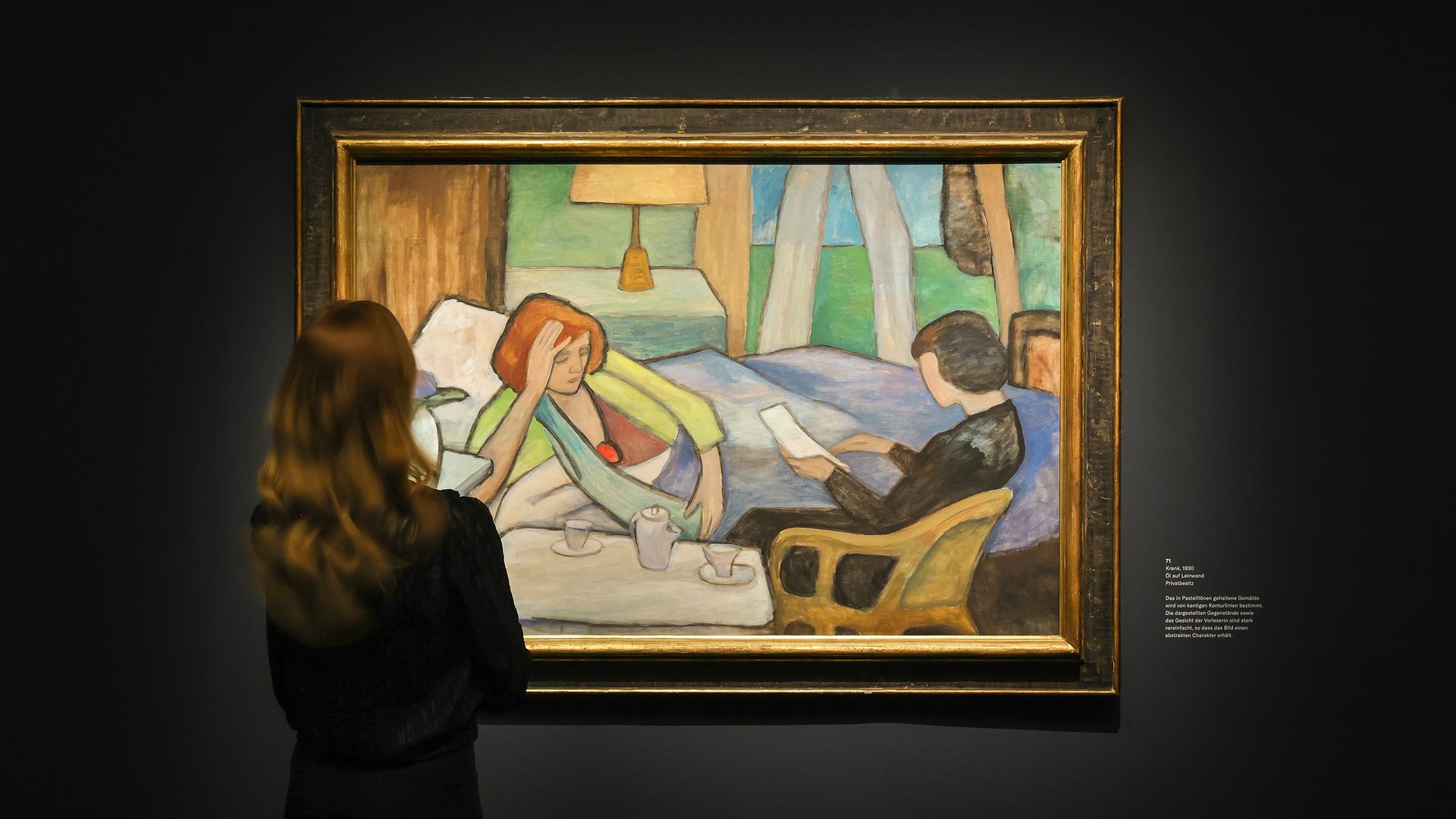 Eine Frau schaut sich ein Gemälde von Gabriele Münter in der Ausstellung "Menschenbilder" im Bucerius Kunst Forum in Hamburg an. Das Gemälde zeigt eine Frau, die halb unter Decken liegt und sich mit der rechten Hand hochstützt, sodass ihr Oberkörper seitlich aufgerichtet ist. Eine andere Frau liest in einem Brief. Eine Frau schaut sich ein Gemälde von Gabriele Münter in der Ausstellung "Menschenbilder" im Bucerius Kunst Forum in Hamburg an. Das Gemälde zeigt eine Frau, die halb unter Decken liegt und sich mit der rechten Hand hochstützt, sodass ihr Oberkörper seitlich aufgerichtet ist. Eine andere Frau liest in einem Brief.