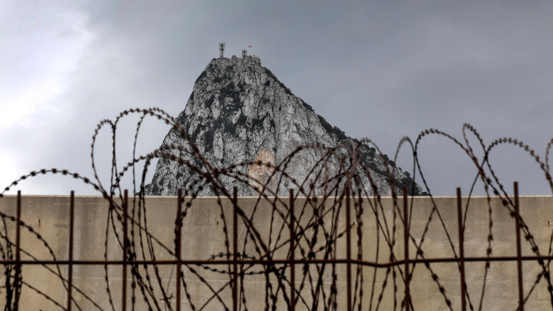 Zaun mit Stacheldraht auf spanischem Gebiet, mit dem Blick auf den Gibraltar Felsen