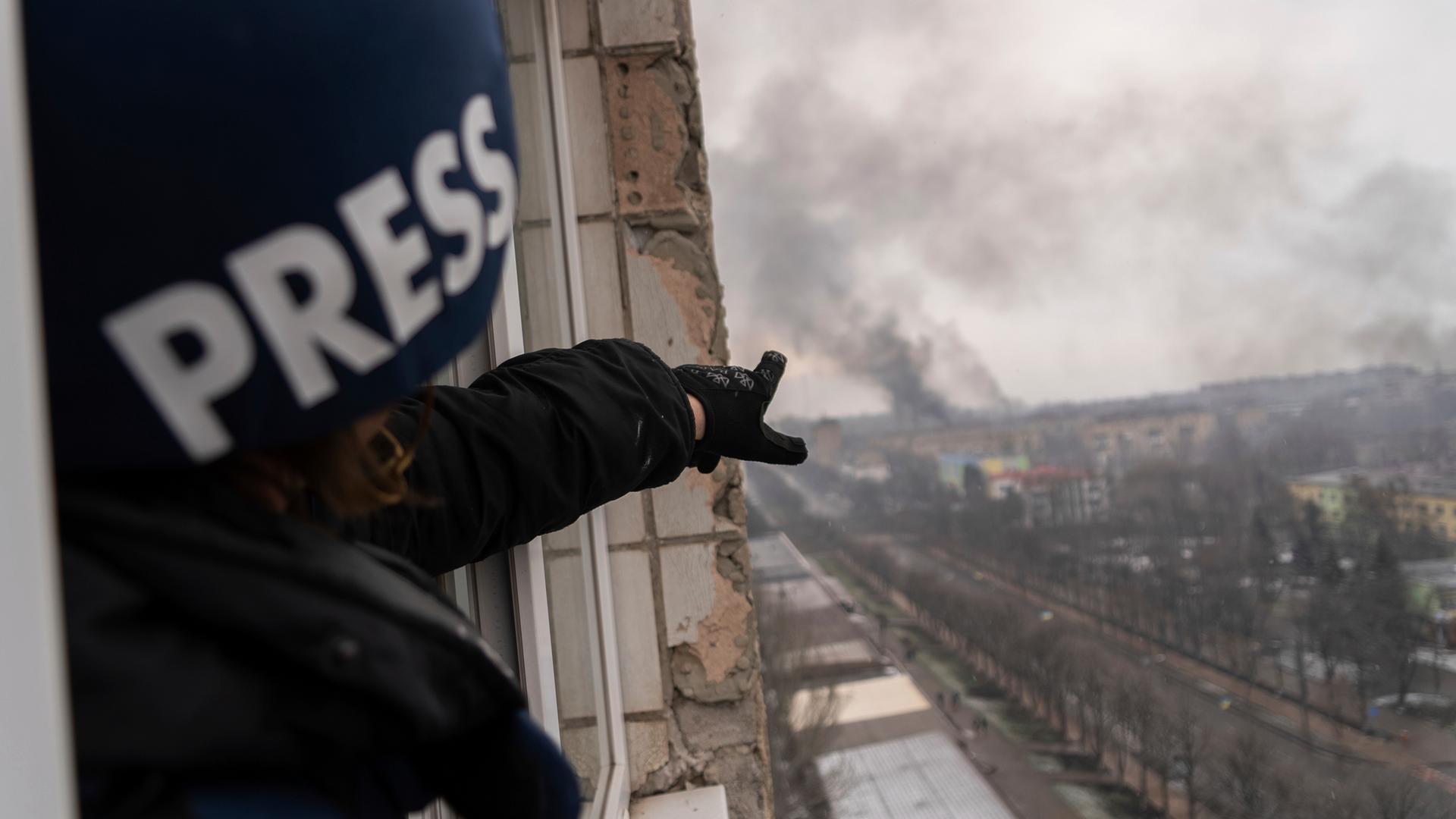 Der Pressefotograf der Agentur Associated Press, Evgeniy Maloletka, deutet auf ein brennendes Entbindungskrankenhaus in Mariupol