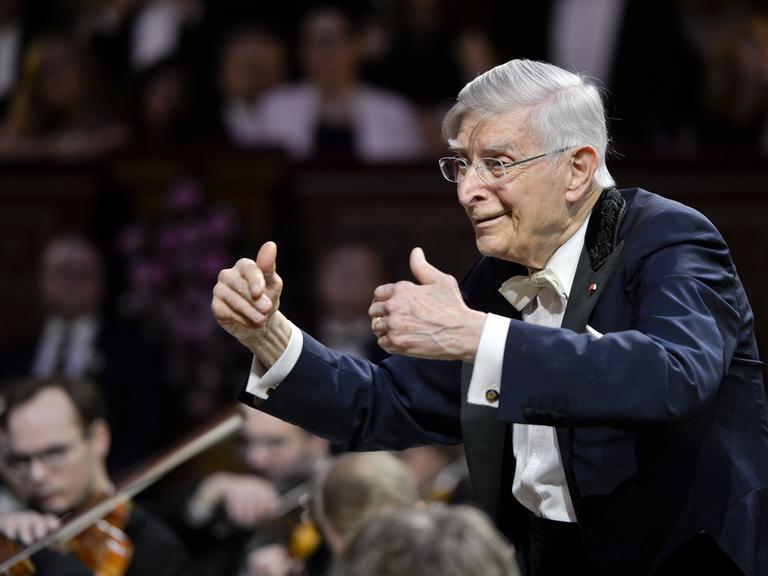 Der Dirigent Herbert Blomstedt dirigiert mit erhobenen Händen.