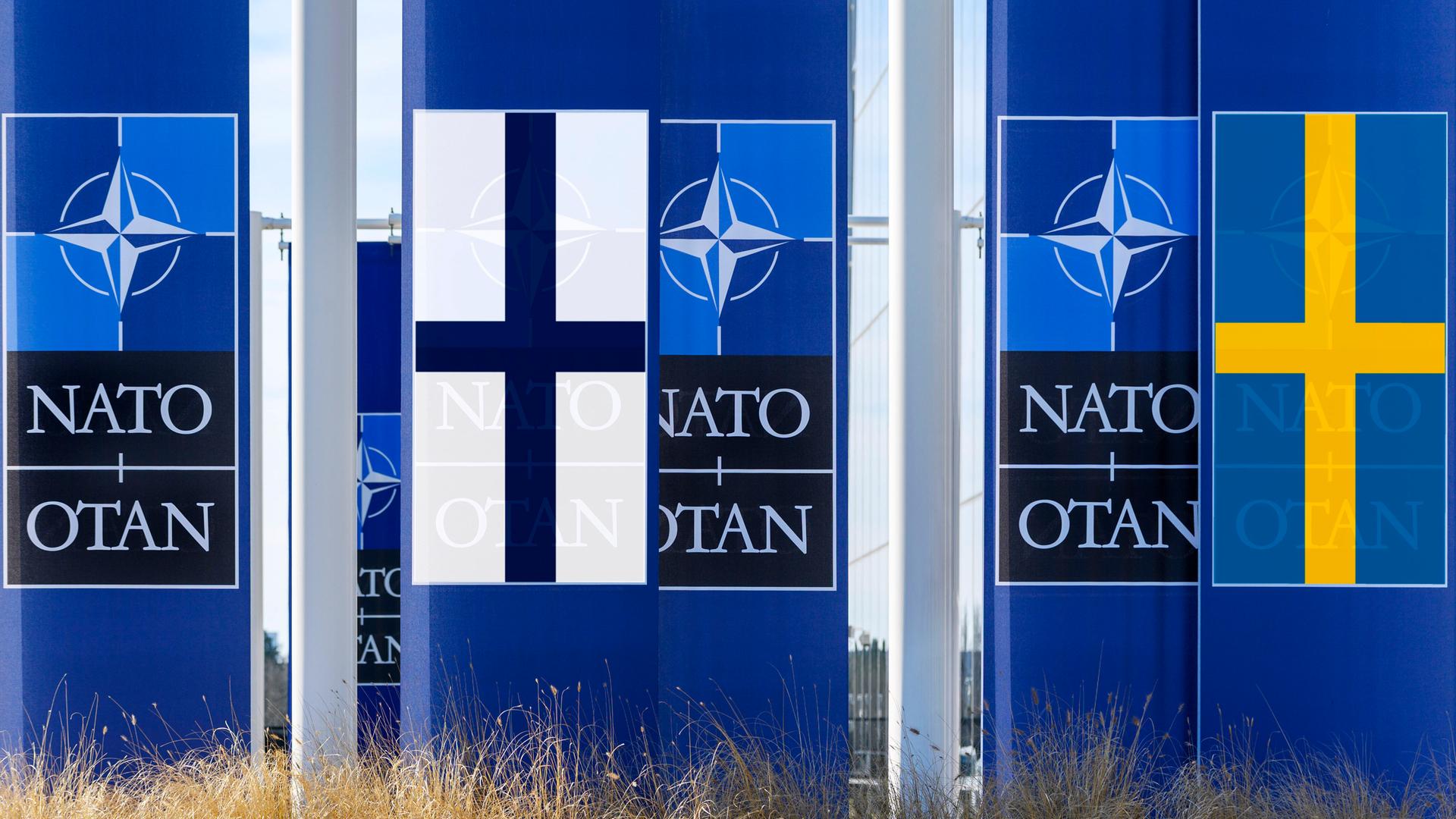 Die Symbole der NATO mit den Fahnen Schwedens und Finnlands. Die Symbole der NATO mit den Fahnen Schwedens und Finnlands.