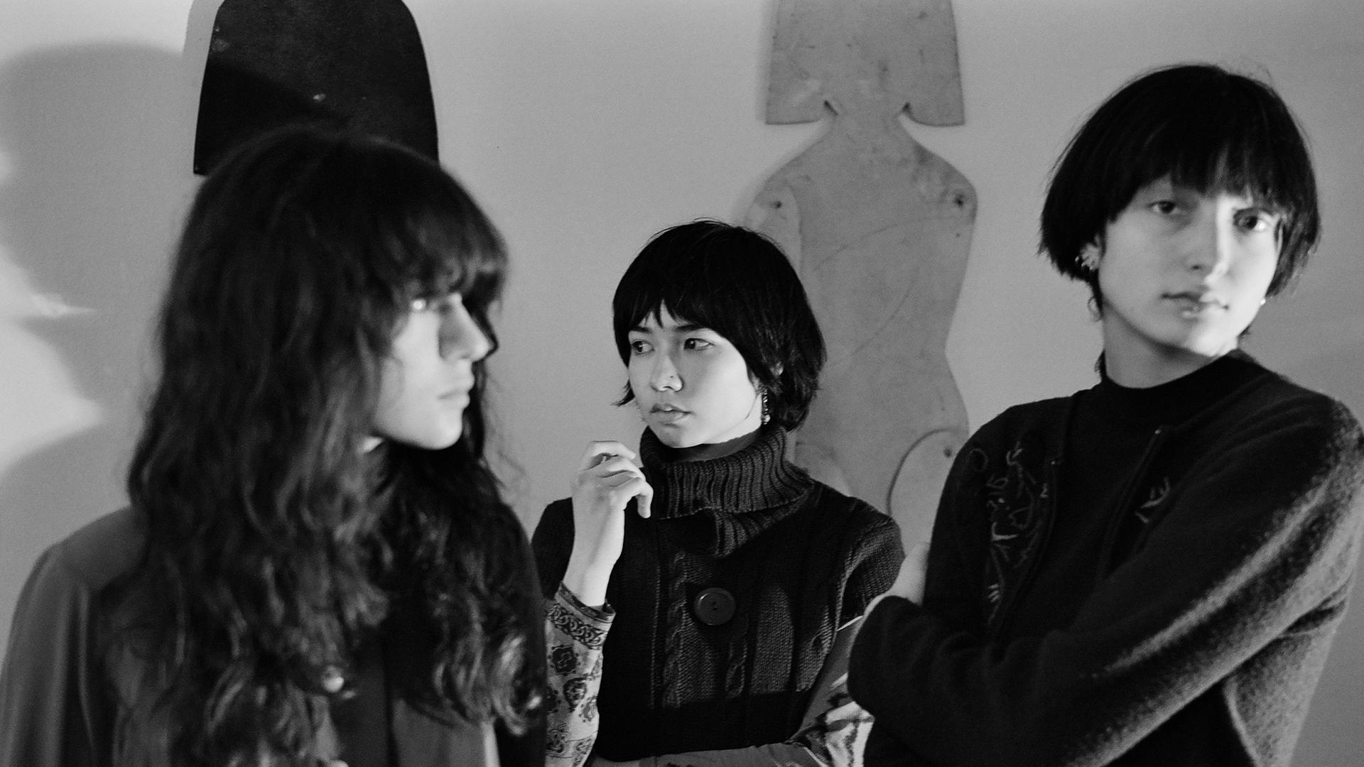 Drei junge Frauen auf einem Schwarz-Weiß-Foto. Die ganz links hat lange Haare, die Frau in der Mitte und die rechts tragen fransige Pilzkopffrisuren.