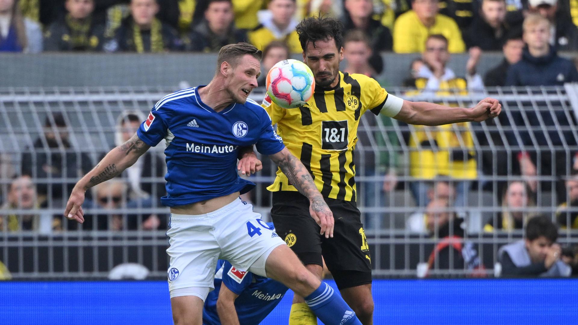 Der Schalke-Spieler Sebastian Polter und der Dortmunder Mats Hummels im Kopfballduell. Der Schalke-Spieler Sebastian Polter und der Dortmunder Mats Hummels im Kopfballduell.