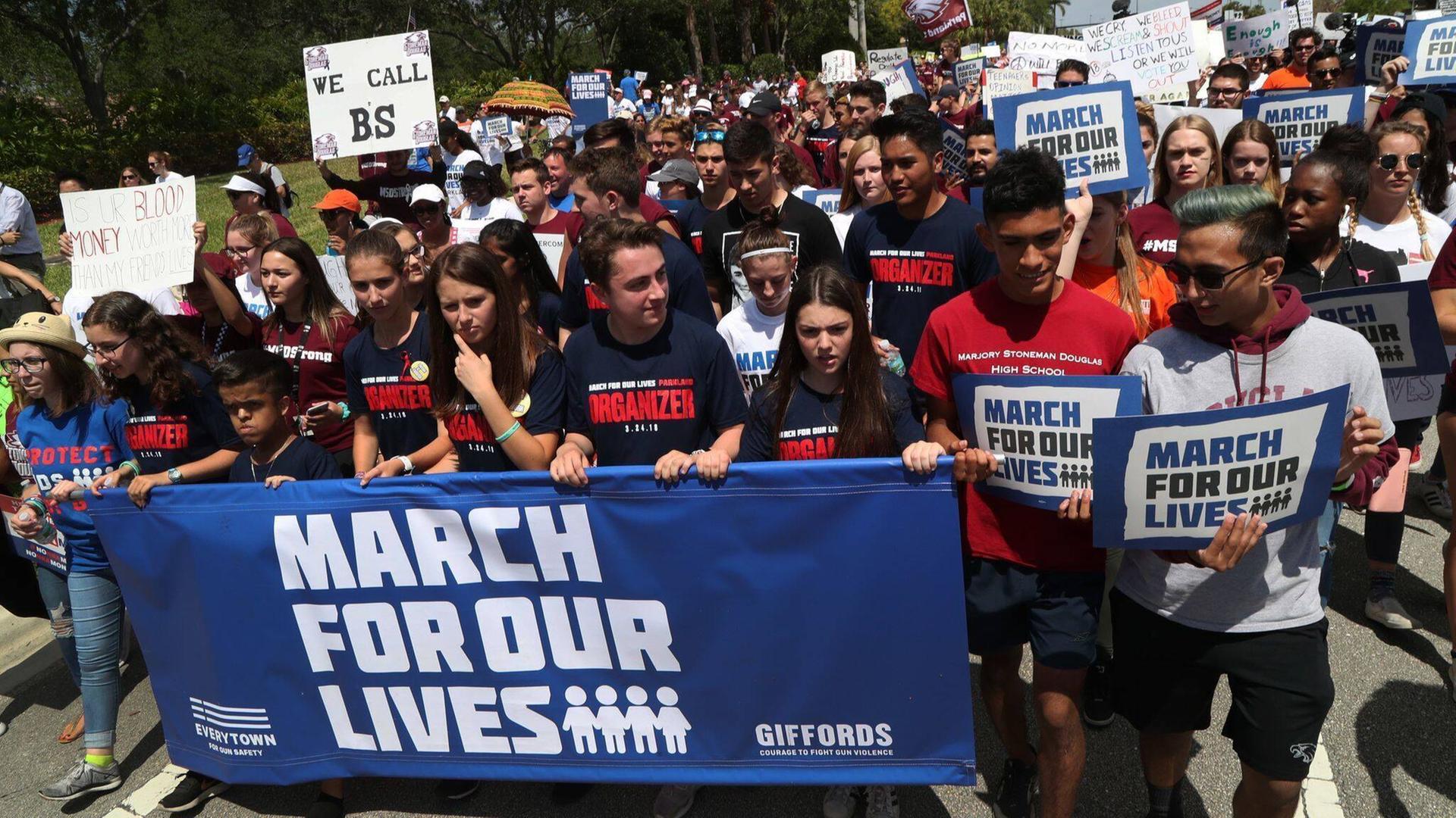Viele junge Menschen demonstrieren, vor sich tragen sie ein Plakat mit der Aufschrift "March For Our Lives". Viele junge Menschen demonstrieren, vor sich tragen sie ein Plakat mit der Aufschrift "March For Our Lives".