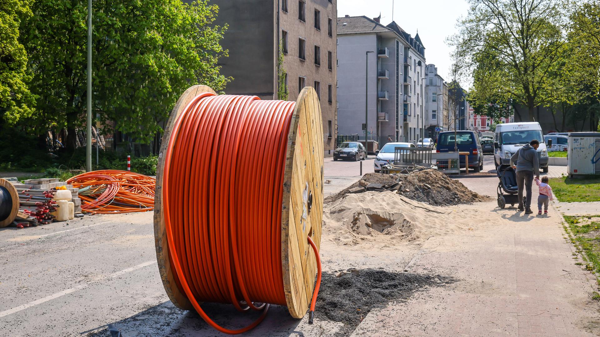 Eine riesige Kabeltrommel mit Glasfaserkabel steht auf einer Straße in Duisburg Eine riesige Kabeltrommel mit Glasfaserkabel steht auf einer Straße in Duisburg