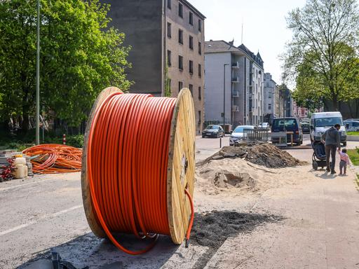 Eine riesige Kabeltrommel mit Glasfaserkabel steht auf einer Straße in Duisburg