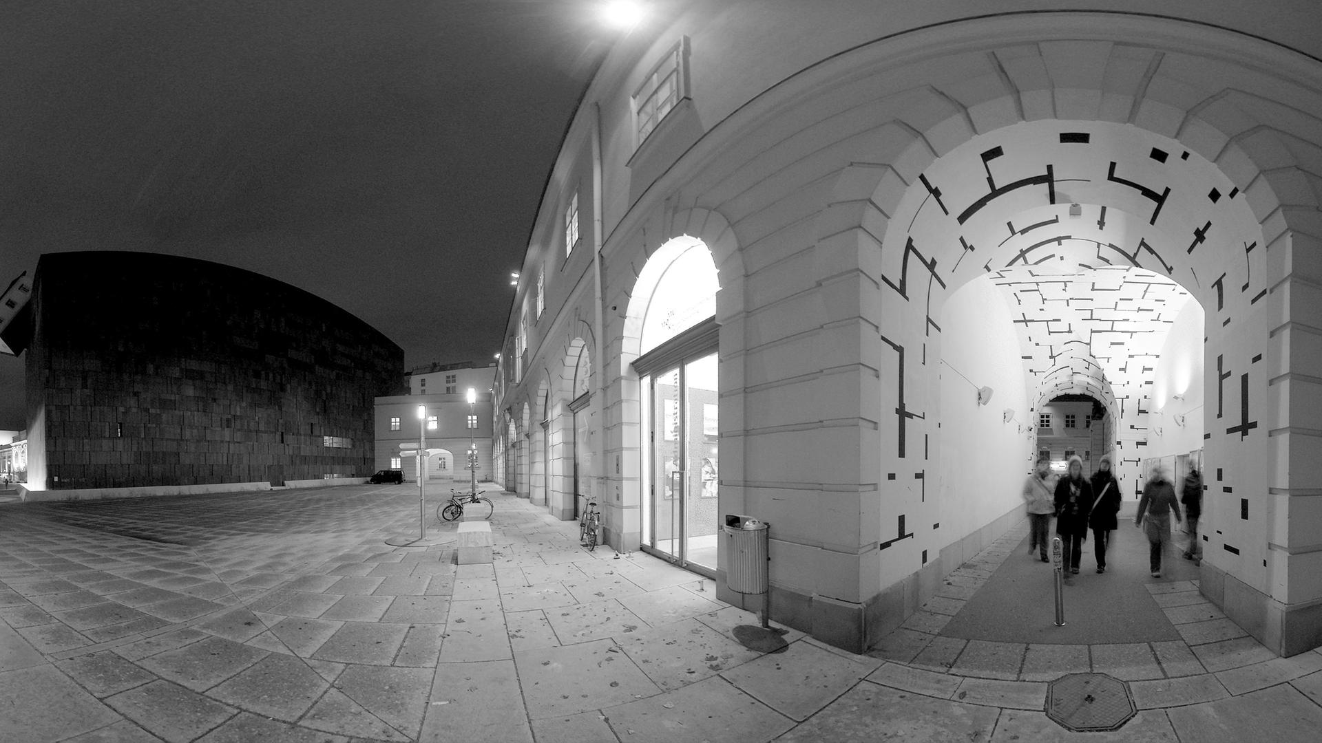 Passanten in der hell erleuchteten TONSPUR-passage am Abend Passanten in der hell erleuchteten TONSPUR-passage am Abend