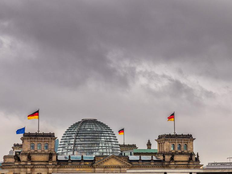 Dunkle Wolken über der gläsernen Kuppel des Reichstagsgebäudes in Berlin
