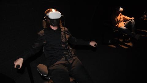 Betrachtende der Arbeit der Künstlerin Loukia Alavanou sitzen im Griechischen Pavillon mit einer Virtual-Reality-Brille auf dem Kopf 2022 auf der 59. Kunstbiennale in Venedig