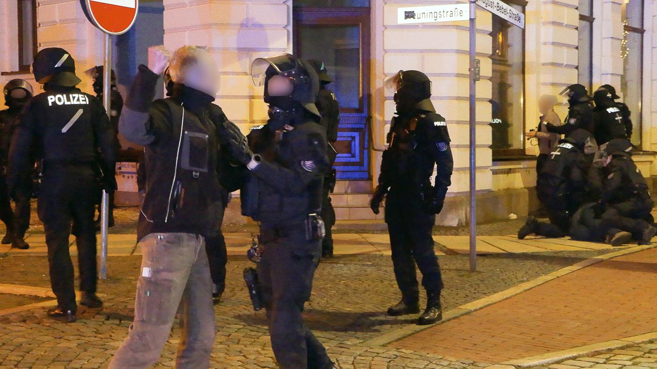 Bei einer Demonstration gegen die deutschen Corona-Maßnahmen im ostthüringischen Greiz bedroht ein Mann einen Polizisten in schwerer Montur mit der Faust. Bei einer Demonstration gegen die deutschen Corona-Maßnahmen im ostthüringischen Greiz bedroht ein Mann einen Polizisten in schwerer Montur mit der Faust.