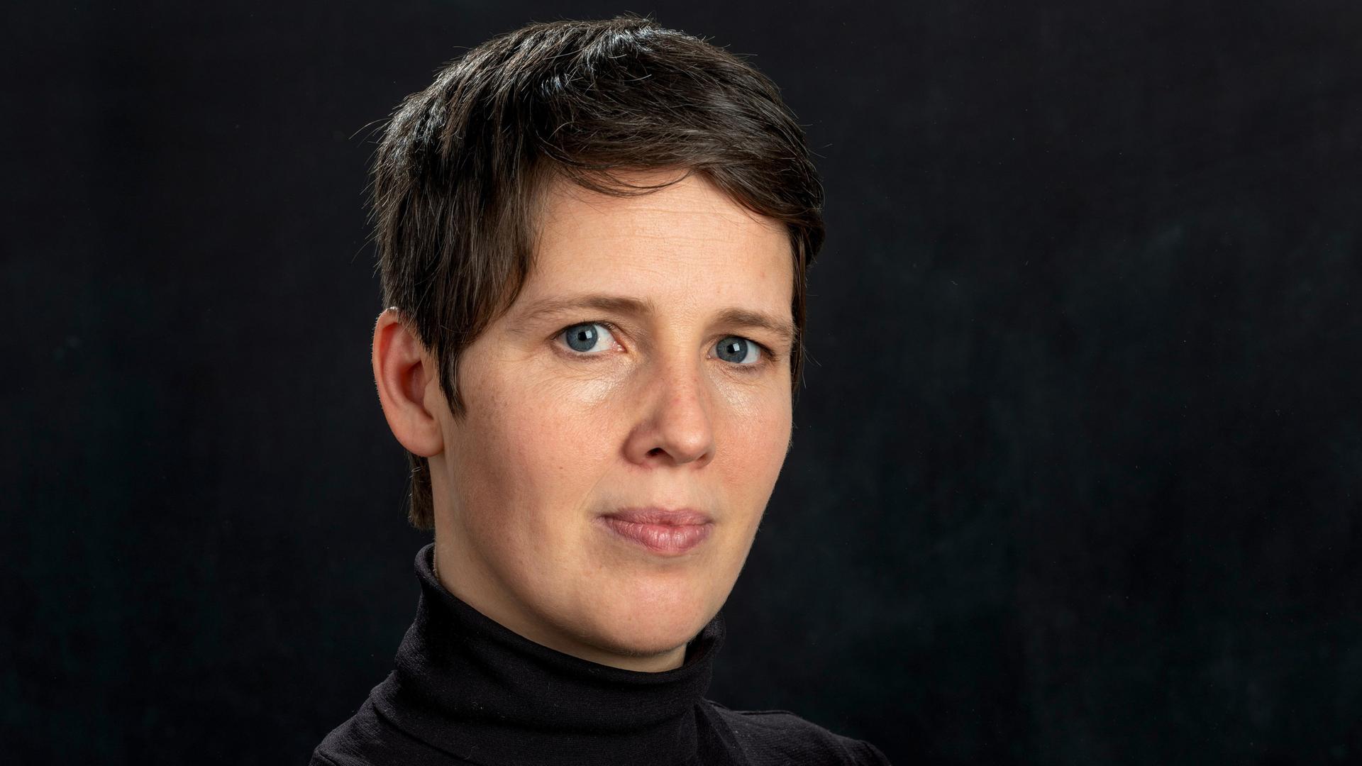 Porträt der Physikerin Viola Priesemann vor dunklem Hintergrund Porträt der Physikerin Viola Priesemann vor dunklem Hintergrund