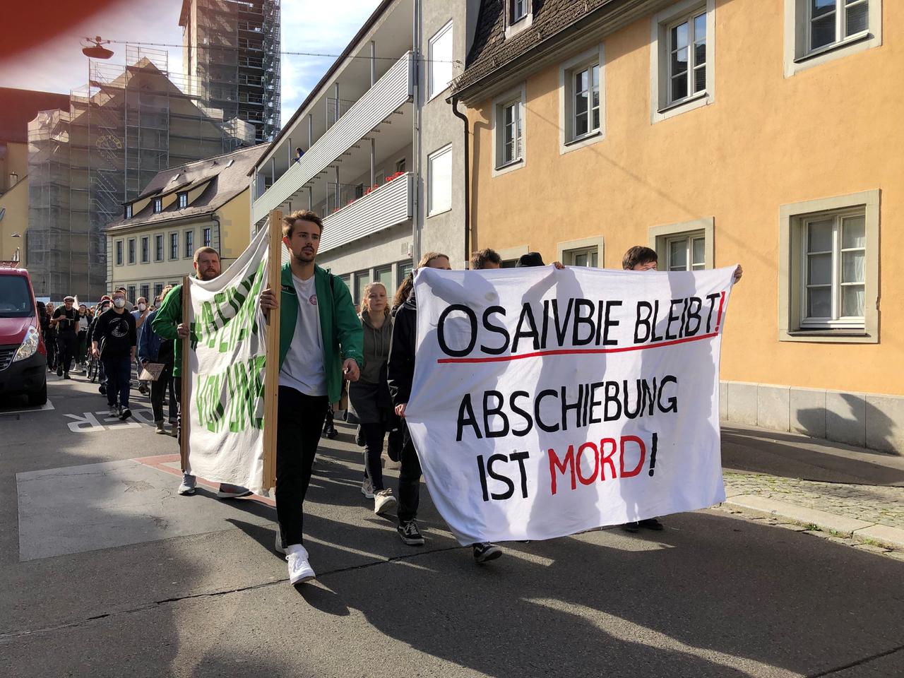 Demonstranten protestieren gegen die Abschiebung. Sie tragen ein Banner mit der Aufschrift " Demonstranten protestieren gegen die Abschiebung. Sie tragen ein Banner mit der Aufschrift "
