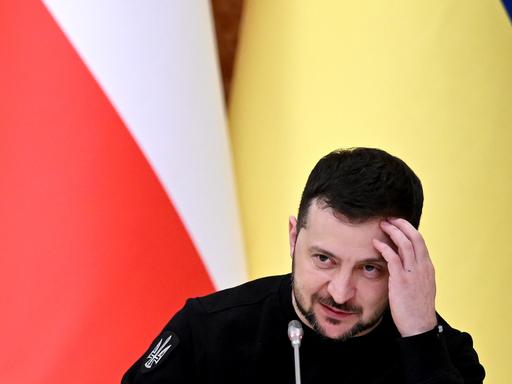 Der ukrainische Präsident Wolodymiyr Selenskiyj kratzt sich bei einer PK in Kiew am Kopf