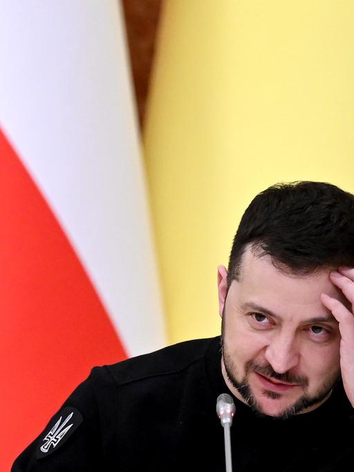 Der ukrainische Präsident Wolodymiyr Selenskiyj kratzt sich bei einer PK in Kiew am Kopf