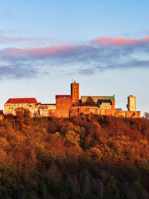 Ausblick auf die Wartburg mit rosa Wolken des Sonnenuntergangs über der Wartburg. 