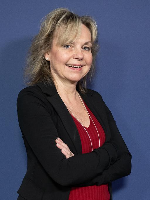 Portrait der Wissenschaftlerin Sabine Döring vor einer blauen Wand.