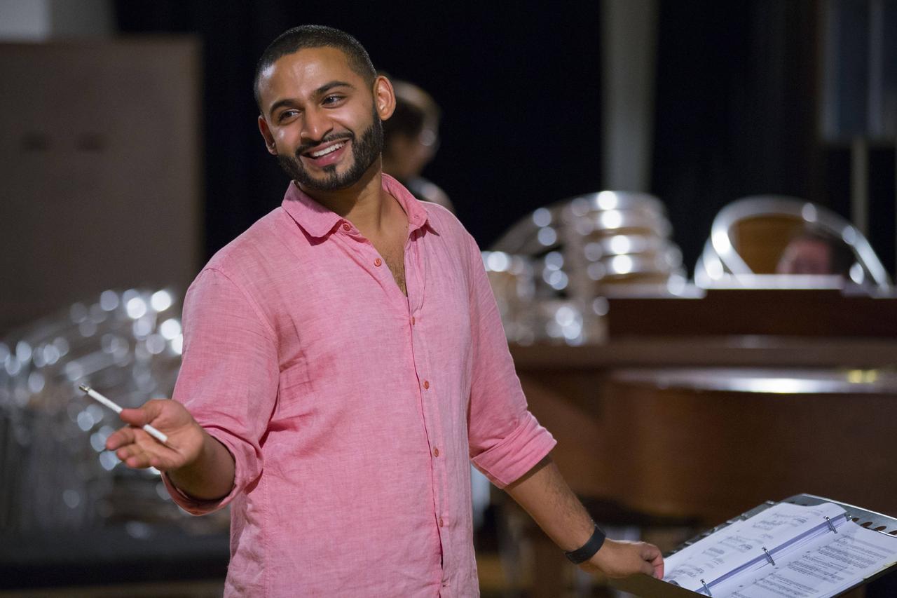 Dirigent Jordan de Souza mit Dirigentenstab bei einer Probe Dirigent Jordan de Souza mit Dirigentenstab bei einer Probe