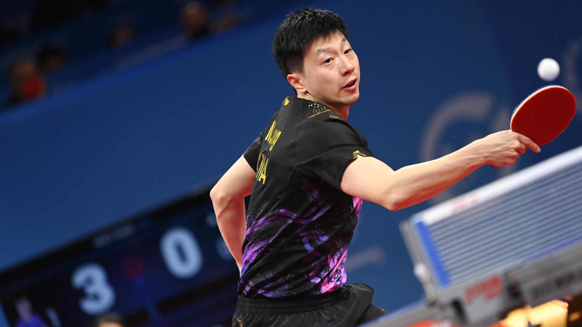 Der Spieler Ma Long spielt einen Ball über die Tisch-Tennis-Platte. Der Spieler Ma Long spielt einen Ball über die Tisch-Tennis-Platte.