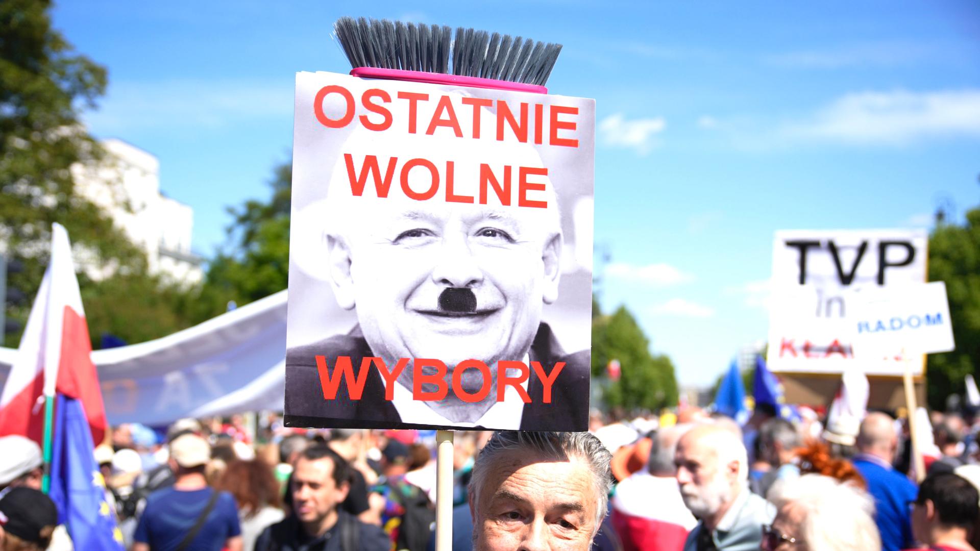 Ein Mann hält ein Plakat in die Höhe, auf dem der Chef der rechtsnationale Regierungspartei PiS, Jaroslaw Kaczynski, zu sehen ist