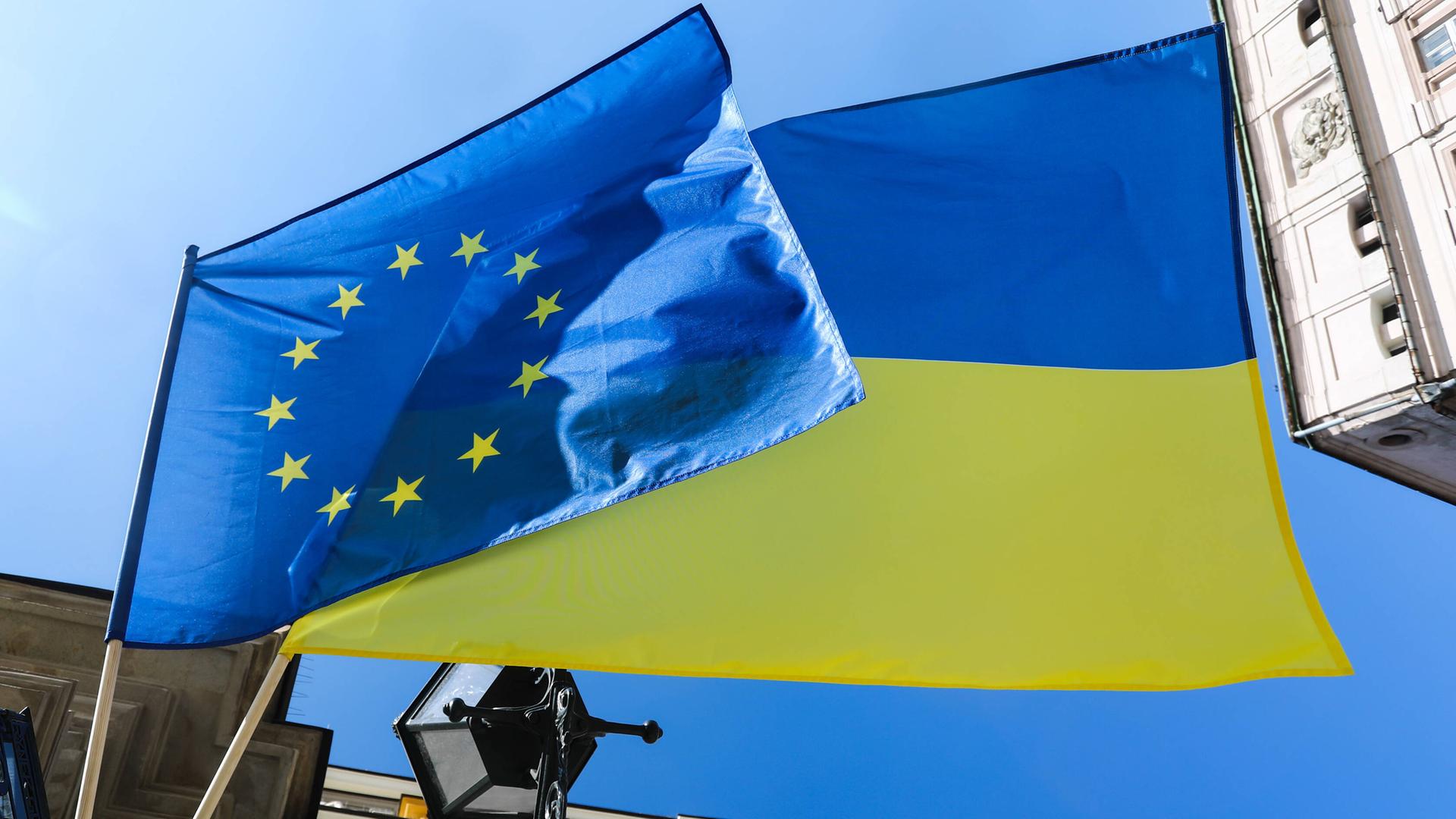 Die Flaggen der Europäischen Union und der Ukraine wehen im Wind.
