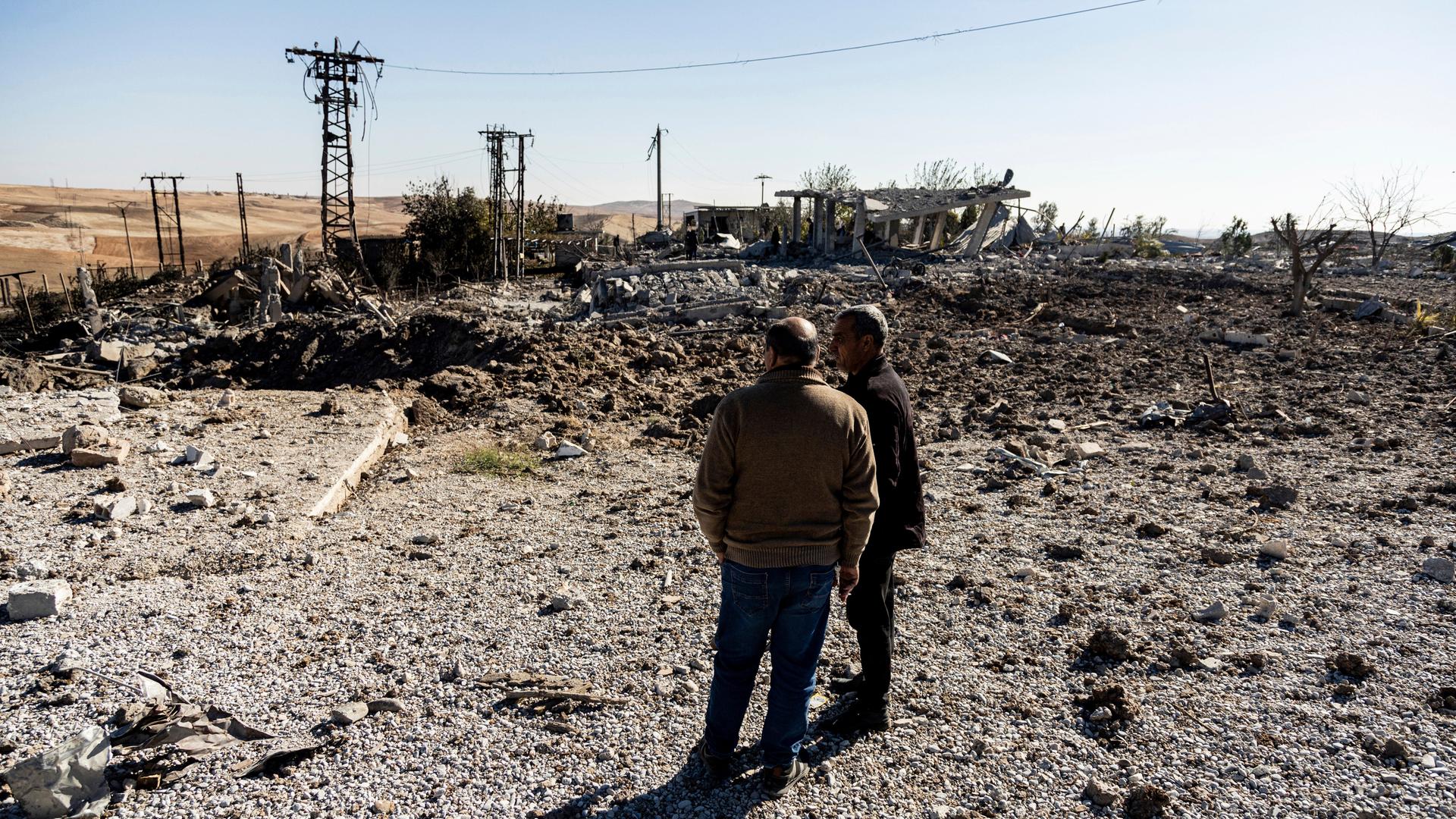 Syrien, Taql Baql: Menschen betrachten einen Ort, der durch türkische Luftangriffe beschädigt wurde, die ein Elektrizitätswerk getroffen haben. 