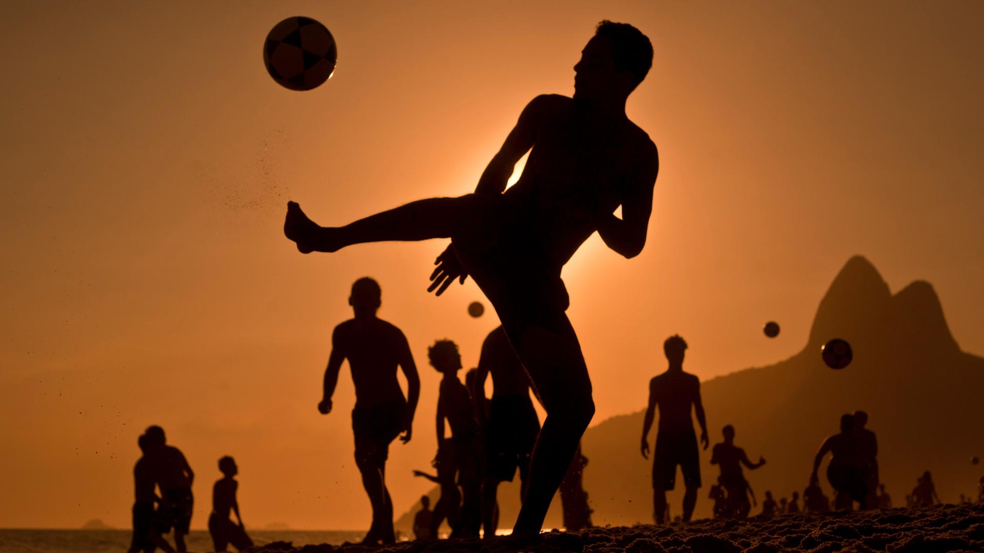 Junge Leute spielen am Strand von Rio Fußballl Junge Leute spielen am Strand von Rio Fußballl
